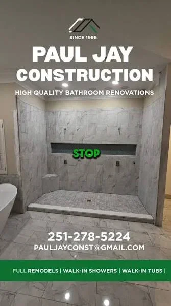 Paul Jay Construction bathroom renovation showcase featuring a modern walk-in shower with marble tile, toilet, and green "STOP" sign, with company branding and contact information